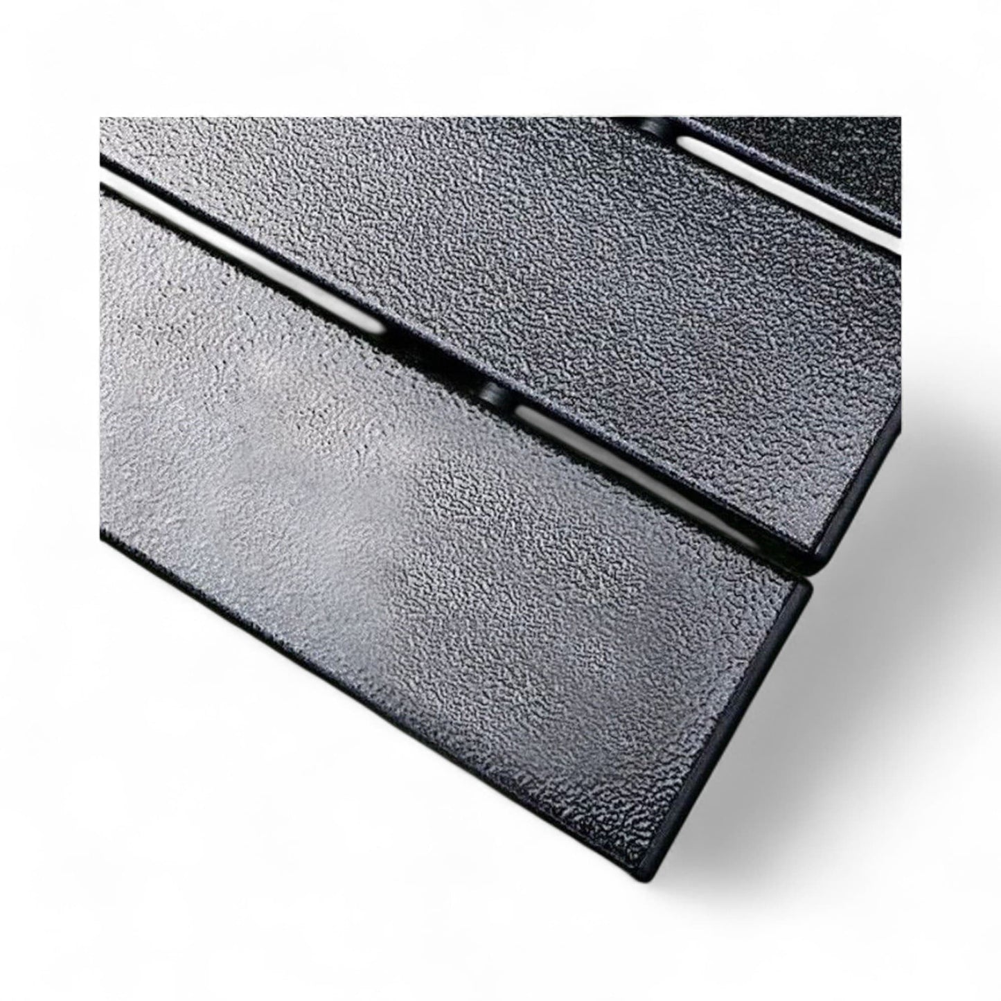 Close-up of a textured black metal surface with a white background