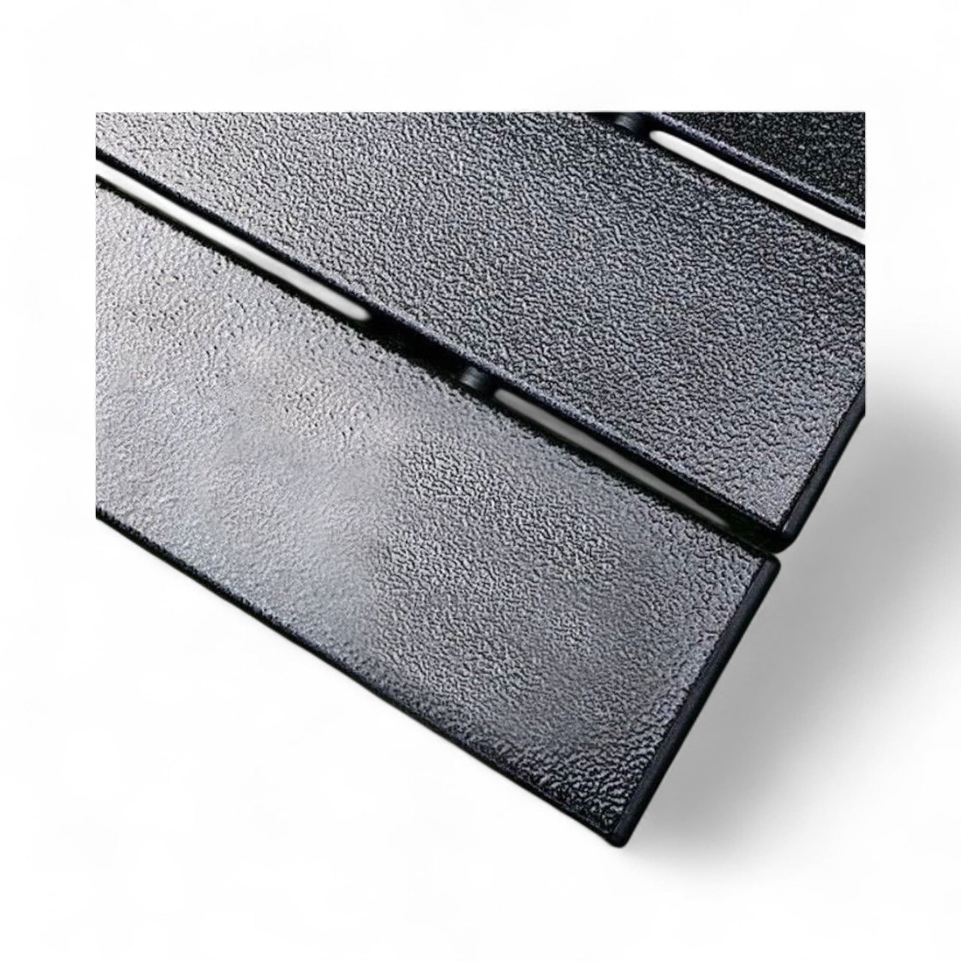 Close-up of a textured black metal surface with a white background
